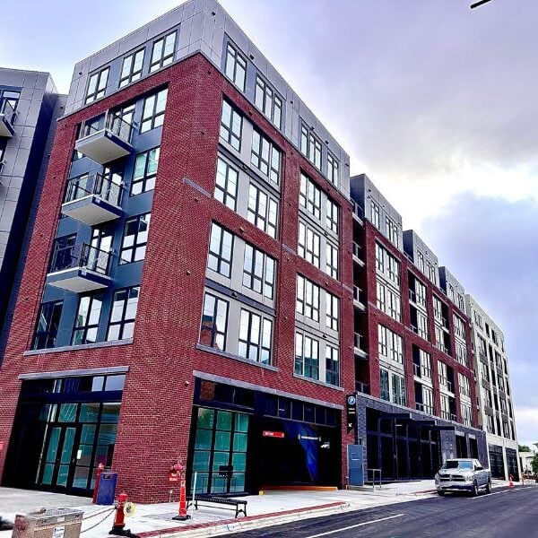 Exterior of 500 E. Main Street in North Carolina featuring 248 residential units, ground floor retail, and a structured parking garage. Showcase commercial masonry work.