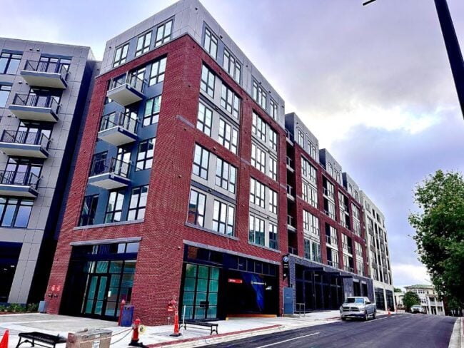 Exterior of 500 E. Main Street in North Carolina featuring 248 residential units, ground floor retail, and a structured parking garage. Showcase commercial masonry work.