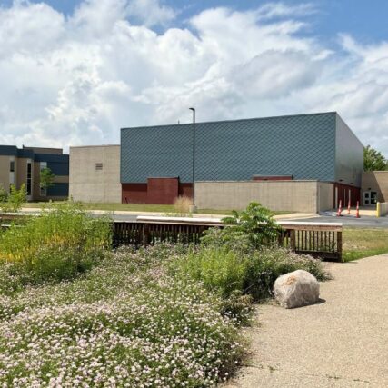 Central Park Elementary School in Midland, MI featuring Boettcher Masonry’s patterned brickwork and landscaped exterior with trees and greenery.