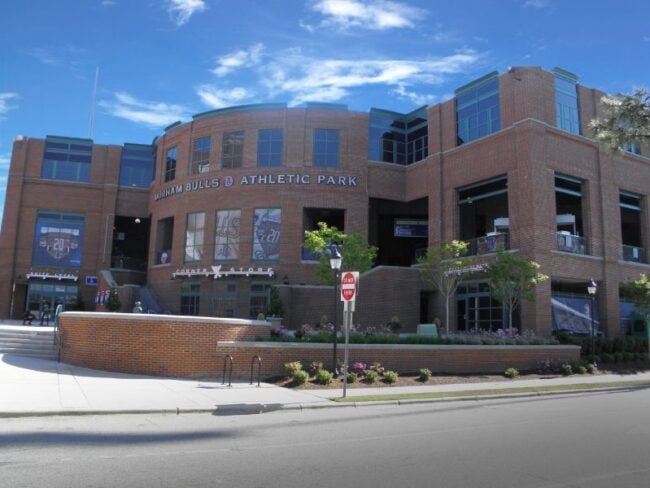 Exterior entrance of Durham Bulls Athletic Park in North Carolina featuring Boettcher Masonry brickwork and stairs leading up to the building.