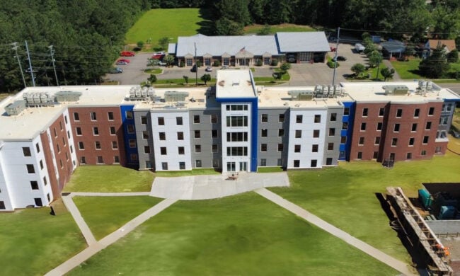 Exterior of Fayetteville State University residence hall featuring Boettcher Masonry’s multi-colored brickwork with bump-outs for dimension, wide sidewalks, and landscaped surroundings. the wide sidewalks and landscaped pathways create an inviting, student-friendly environment.