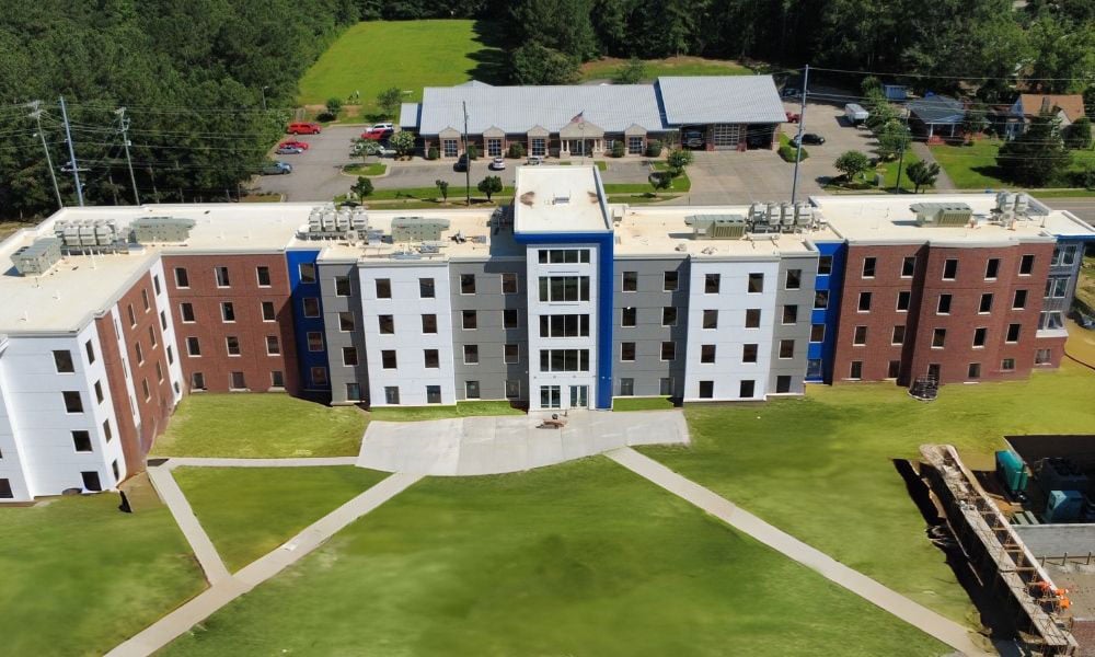 Exterior of Fayetteville State University residence hall featuring Boettcher Masonry’s multi-colored brickwork with bump-outs for dimension, wide sidewalks, and landscaped surroundings. the wide sidewalks and landscaped pathways create an inviting, student-friendly environment.
