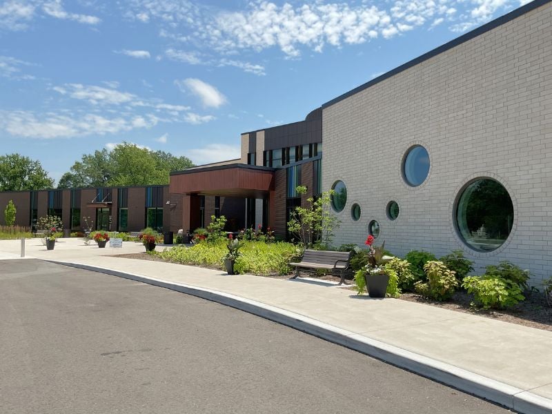 Walkway leading up to Greater Midland Community Center with Boettcher Masonry brick veneer, round windows, and landscaped surroundings.