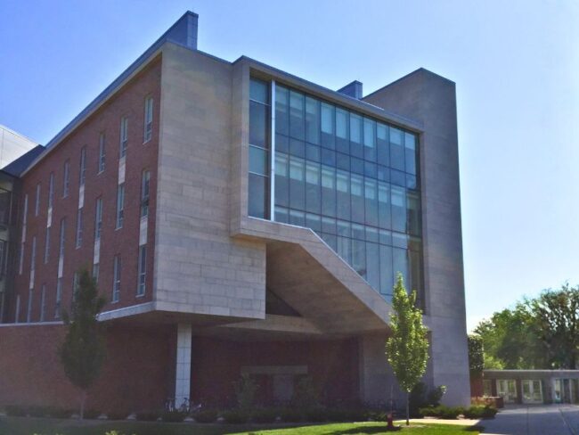 Exterior of Michigan State University’s Wells Hall expansion showcasing Boettcher Masonry’s craftsmanship with limestone from Capital Stoneworks and “Rustic Blend” brick from Sioux City Brick & Tile Company, combining warmth and texture in a modern vertical design.