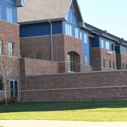 Long brick enclosure wall leading to the entrance of Northwood University’s North Village Apartments, showcasing Boettcher Masonry’s detailed brick craftsmanship.