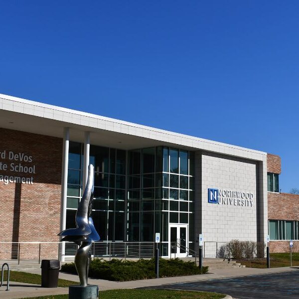 Entrance of Northwood University’s Richard DeVos Graduate School of Management featuring light and dark brick veneer over CMU with Boettcher Masonry’s Arriscraft clip system and statue in front.