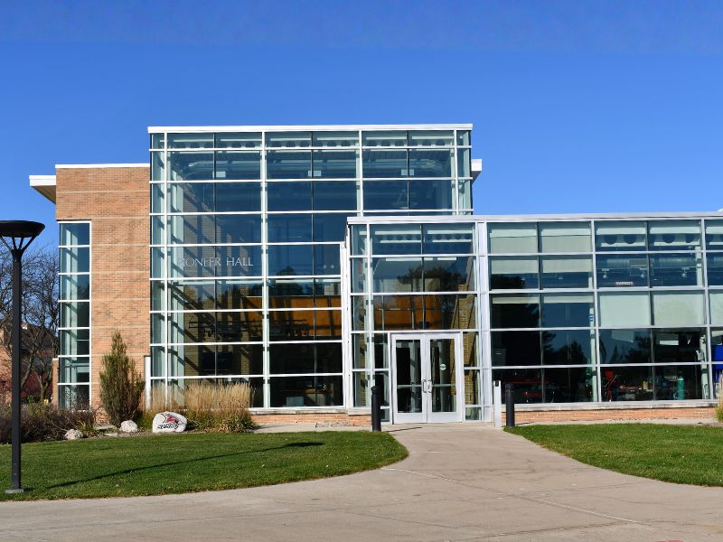 Exterior of Saginaw Valley State University’s Pioneer Hall featuring a brick base with modern glass-filled expansion housing specialized engineering labs, highlighting Boettcher Masonry’s craftsmanship.