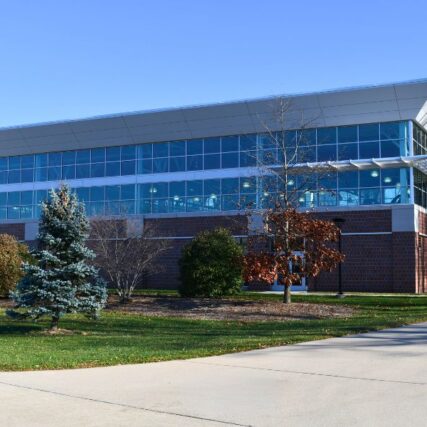 Exterior of Saginaw Valley State University’s Ryder Center Addition with brick, insulated metal wall panels, and glass designed to complement the existing campus architecture.