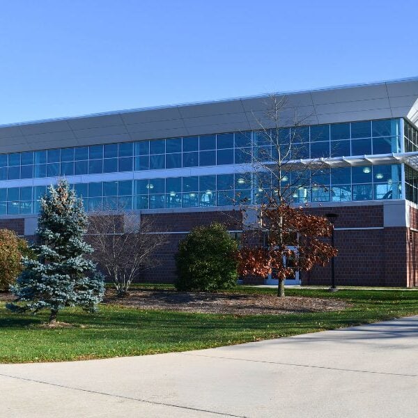 Exterior of Saginaw Valley State University’s Ryder Center Addition with brick, insulated metal wall panels, and glass designed to complement the existing campus architecture.