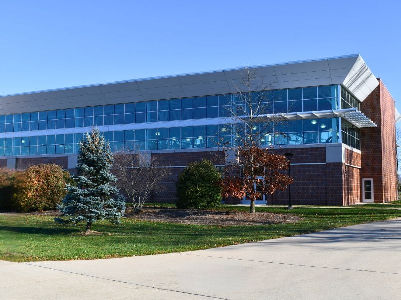 Exterior of Saginaw Valley State University’s Ryder Center Addition with brick, insulated metal wall panels, and glass designed to complement the existing campus architecture.