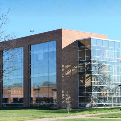 Exterior of Saginaw Valley State University’s Scott L. Carmona College of Business highlighting expansive glass façade with Boettcher Masonry brickwork accents.