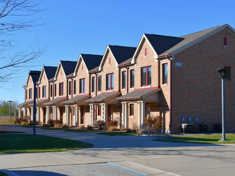 Exterior of Saginaw Valley State University Student Housing featuring brick veneer buildings with pillars and residential-style architecture by Boettcher Masonry.